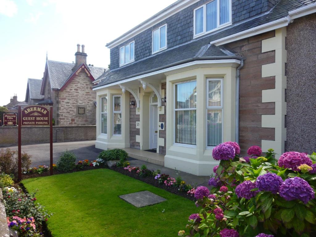 una casa con flores púrpuras en el patio en Abermar Guest House en Inverness