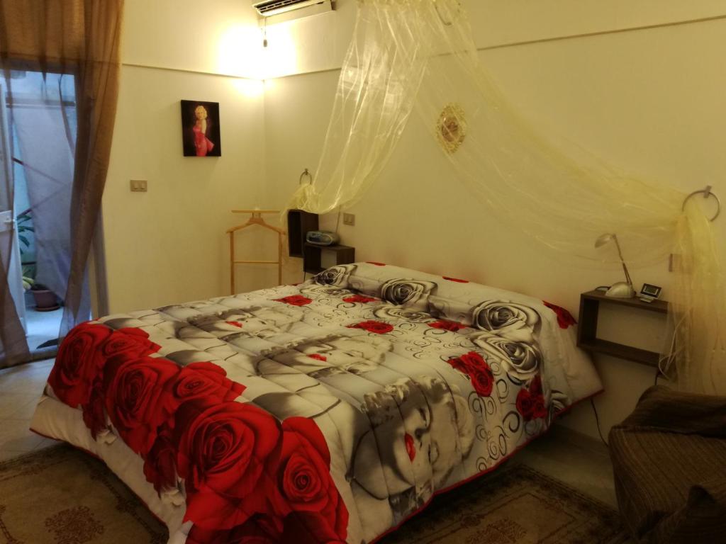 sypialnia z łóżkiem z czerwonymi różami w obiekcie terra e mare w mieście Collemeto