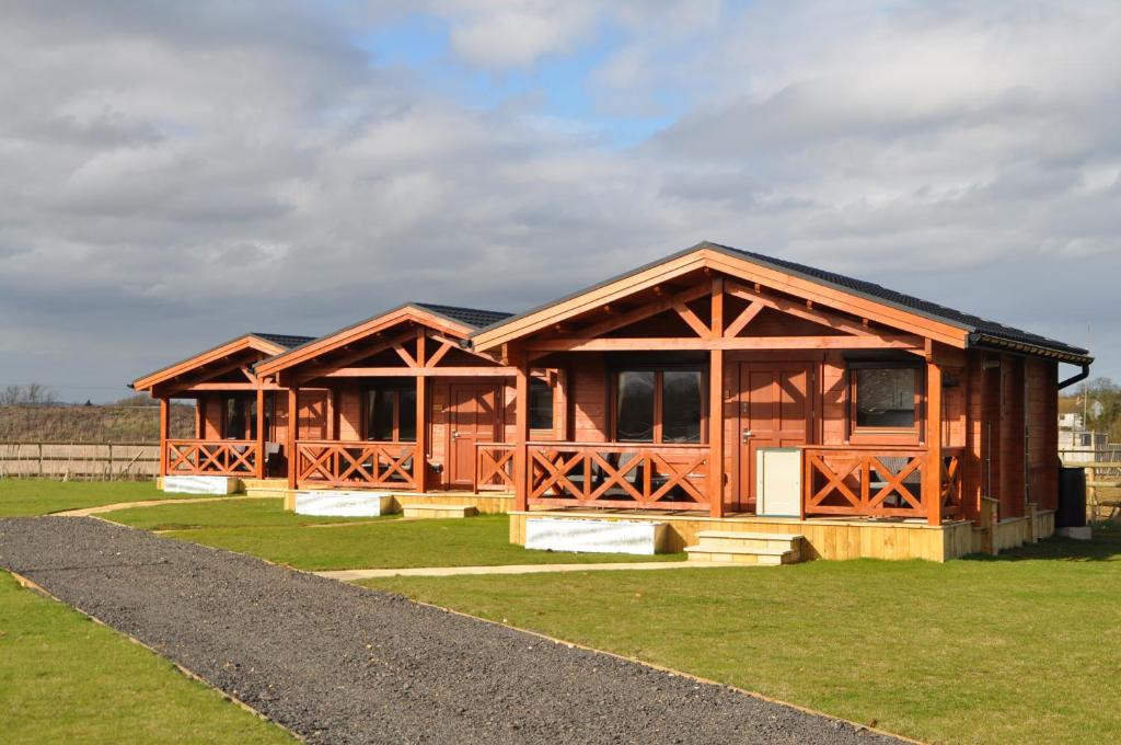 Northwick Farm Lodges في برودواي: كابينة خشبية كبيرة على حقل عشبي