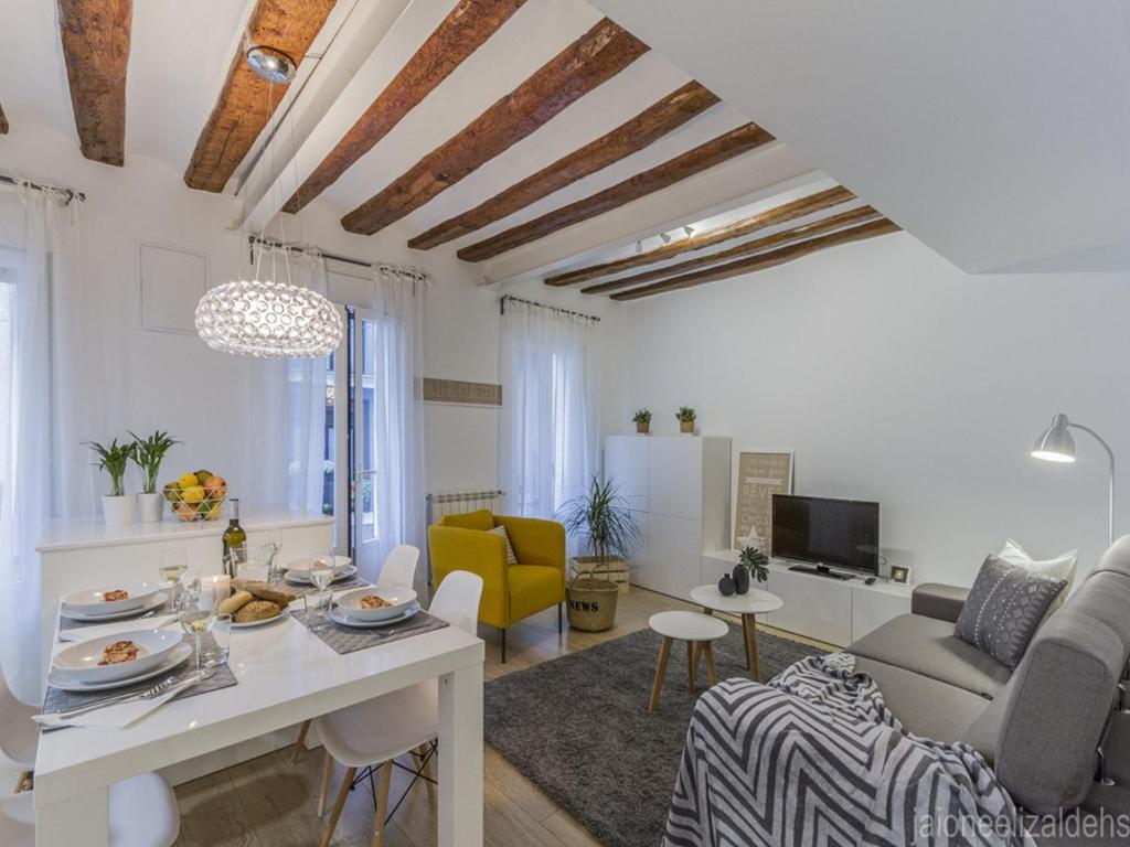 a white living room with a table and a couch at Center Pamplona Apartment in Pamplona