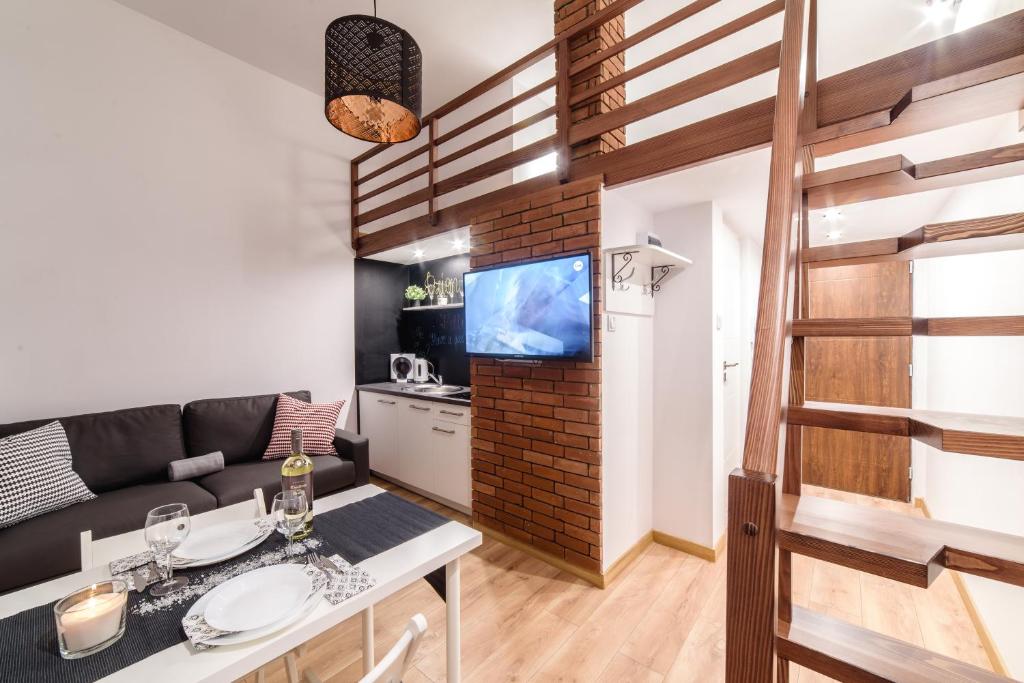 a living room with a couch and a tv at 2 Nights Apartments - great location, right next to Main Rail and Bus Station, 10 min to Main Square by foot in Kraków