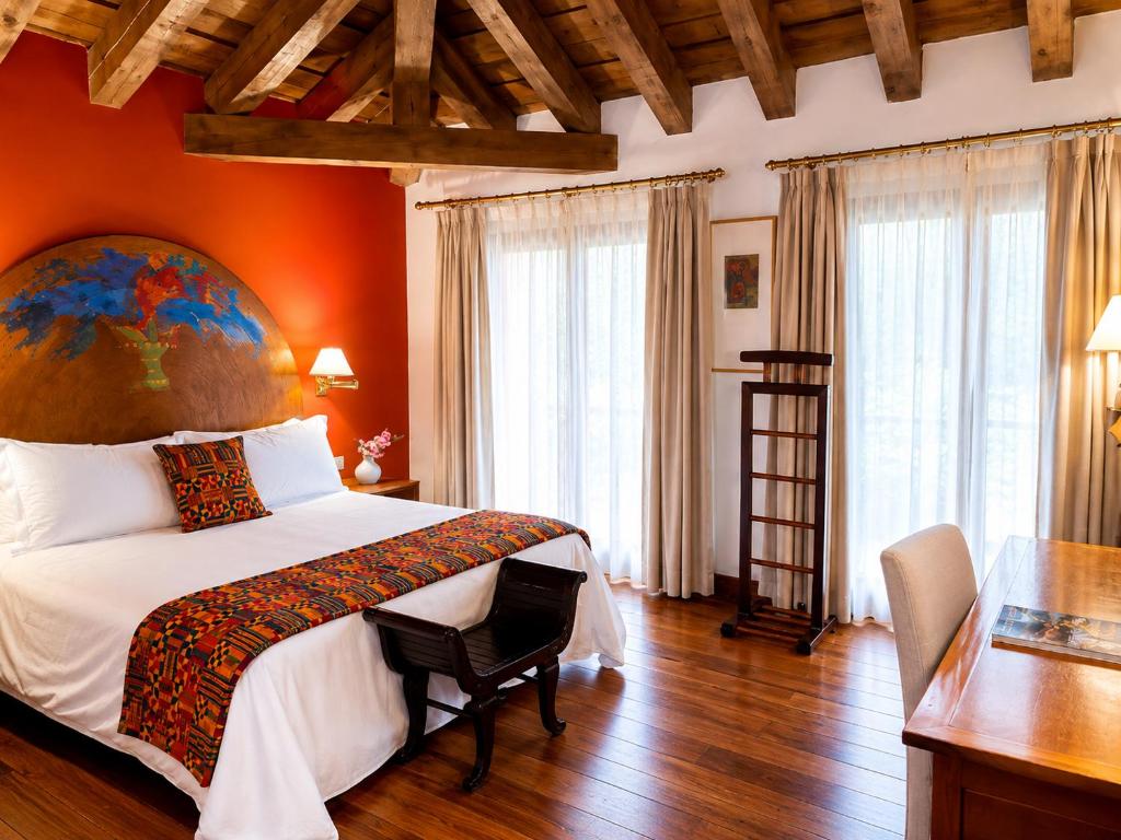 un dormitorio con una cama grande y una pared naranja en Hotel El Rancho, en Segovia