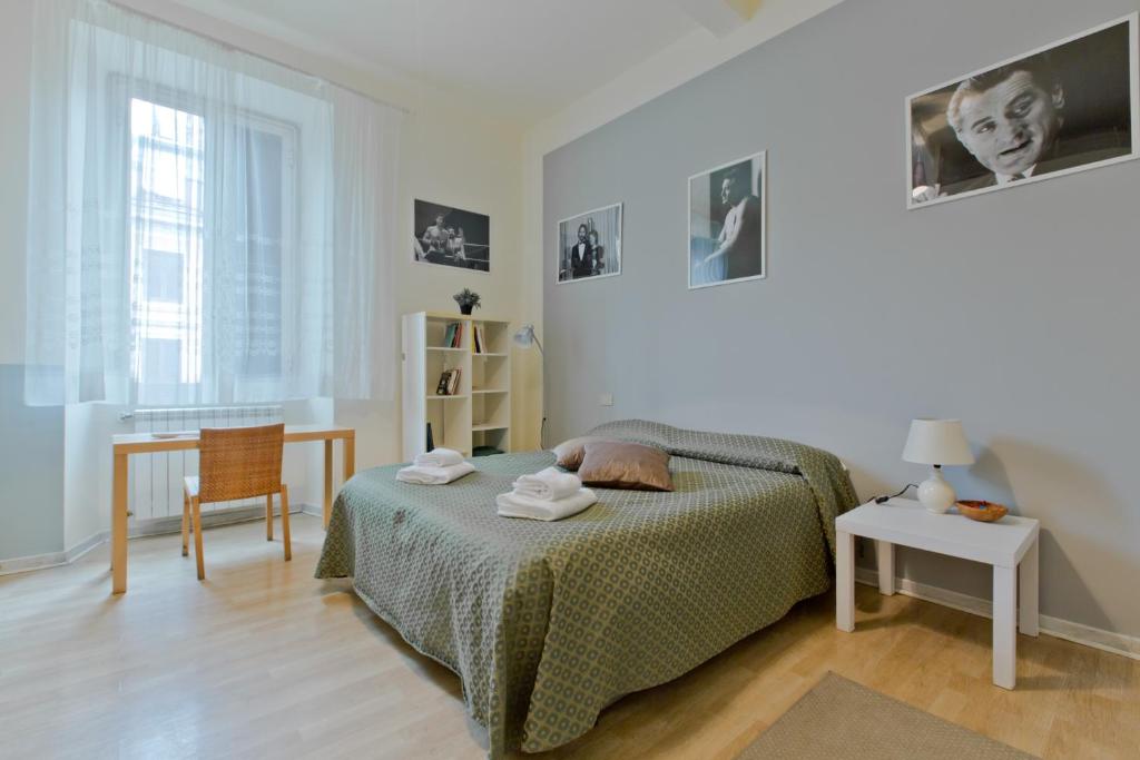 ein Schlafzimmer mit einem Bett und einem Tisch mit einem Stuhl in der Unterkunft Oscar Rooms in Rom