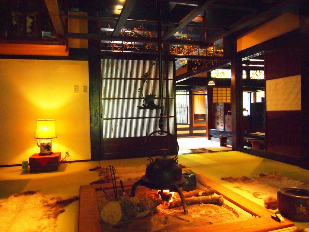 a kitchen with a stove and a lamp in a room at Yamazatonoiori Soene in Takayama