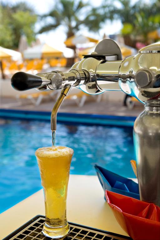 ein Getränk auf einem Tisch neben einem Pool in der Unterkunft Lagoona by Isrotel Collection in Eilat
