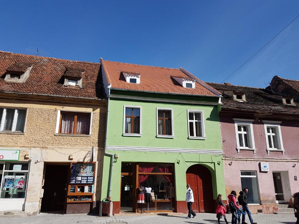 a group of people walking in front of a green building at Chic Studio Brasov in Braşov