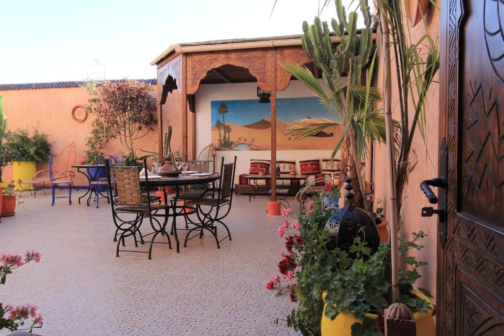 Maison du Soleil في تزنيت: فناء مع طاولة وكراسي والنباتات