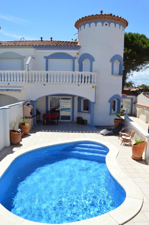 a villa with a swimming pool in front of a house at Raquel Koky in Empuriabrava