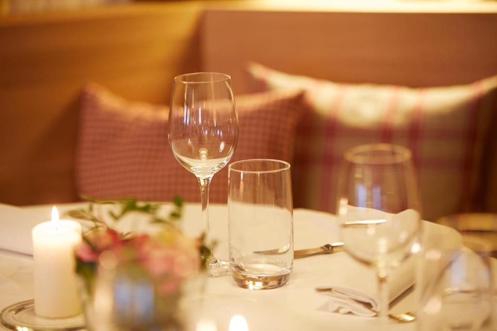 einen Tisch mit zwei Weingläsern und einer Kerze darauf in der Unterkunft Hotel Gasthof Zu den Linden in Oberhundem