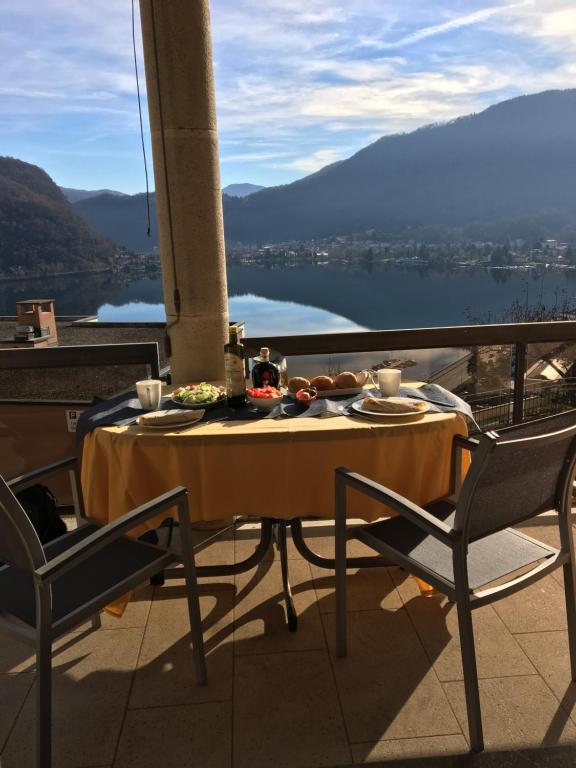 una mesa y sillas en un balcón con vistas en Appartement Novotna en Ponte Tresa