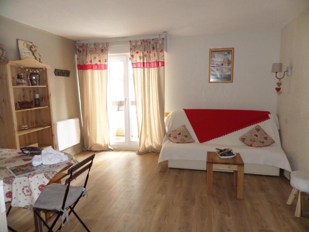 a bedroom with a bed and a table and a window at Appartements Les Balcons du Soleil in Font-Romeu