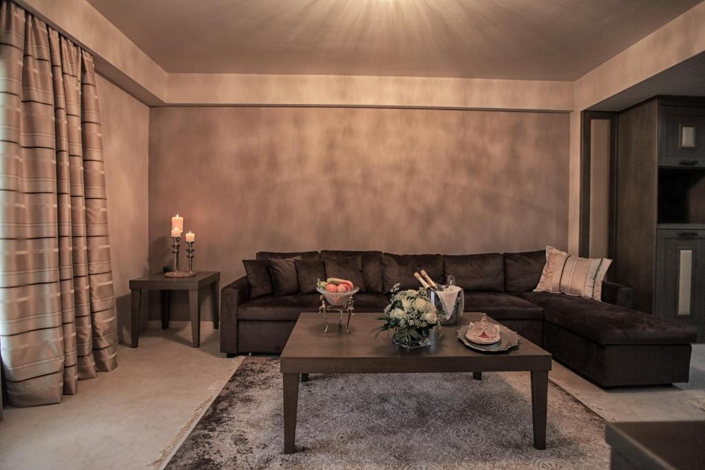 a living room with a couch and a table at Grand Meteora Hotel in Kalabaka