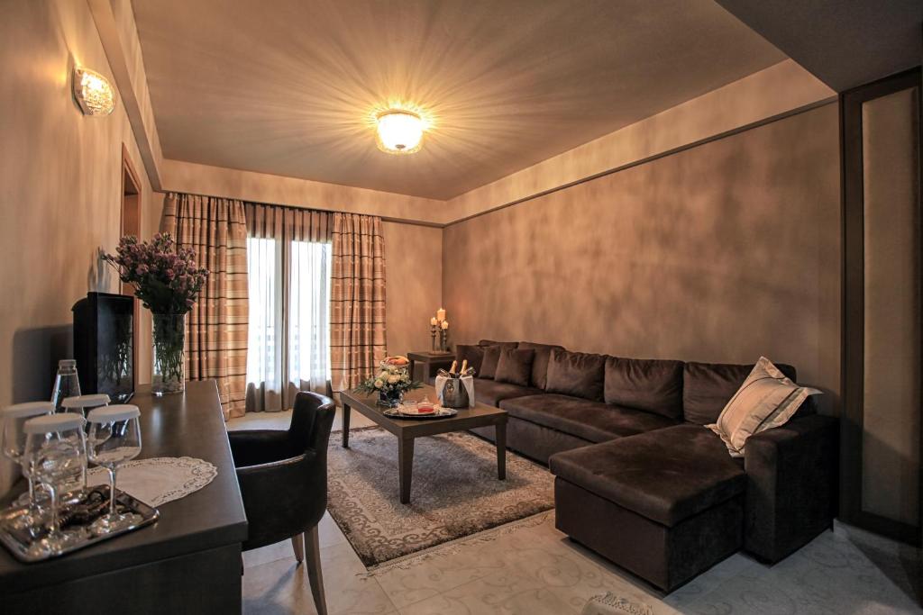 a living room with a couch and a table at Grand Meteora Hotel in Kalabaka