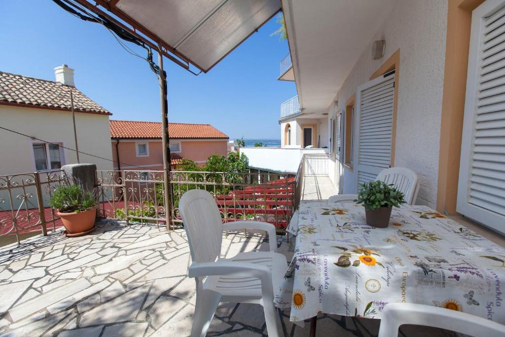 eine Terrasse mit einem Tisch und Stühlen auf dem Balkon in der Unterkunft Apartmenthaus"Kala" in Crikvenica