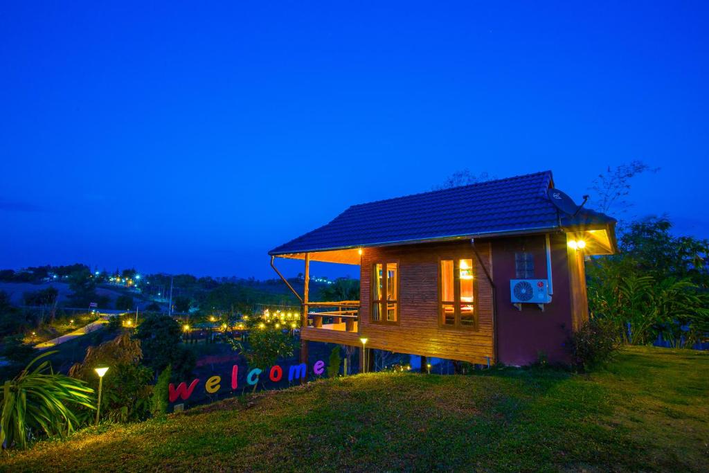 ein kleines Holzhaus mit Lichtern in der Nacht in der Unterkunft Tarahill Khao Kho in Khao Kho