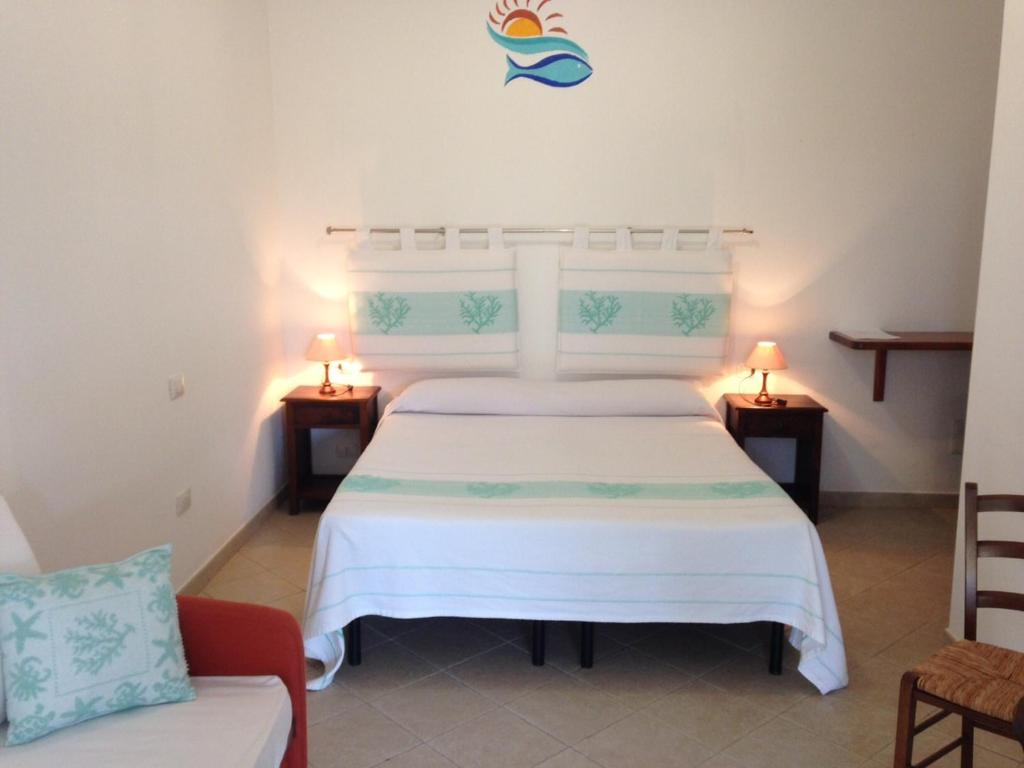 サン・パスクアーレにあるLa Striscia Largaのベッドルーム1室(ベッド1台、テーブル2台、ソファ付)