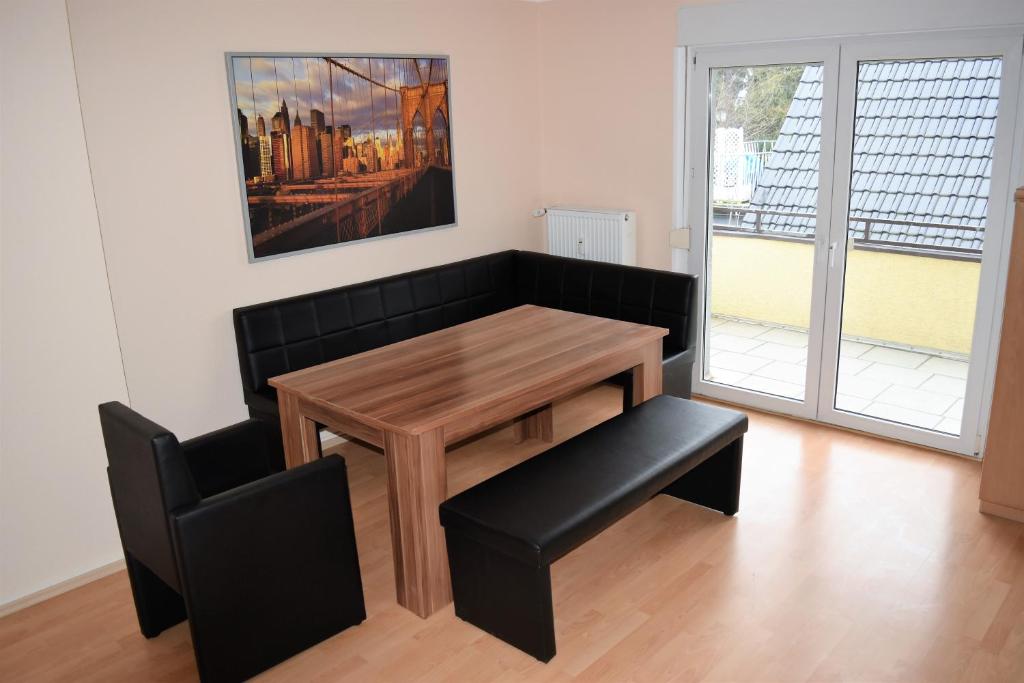 a dining room with a wooden table and a chair at Ferienwohnungen Leverkusen Schlebusch in Leverkusen