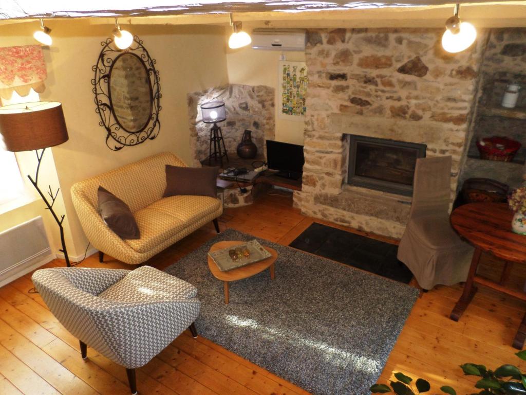 sala de estar con sofá y chimenea en La Belle Poule - FAVEROLLE en Villefranche-de-Rouergue