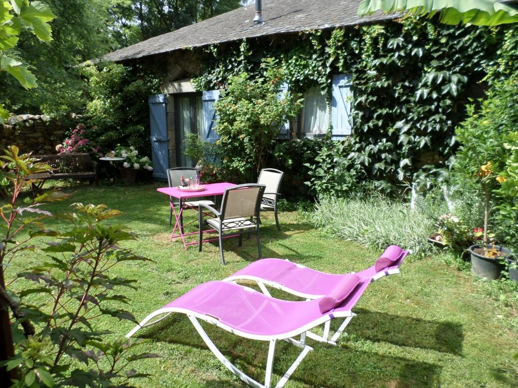 einen rosa Tisch und Stühle im Garten in der Unterkunft La Belle Poule - SEBRIGHT in Villefranche-de-Rouergue