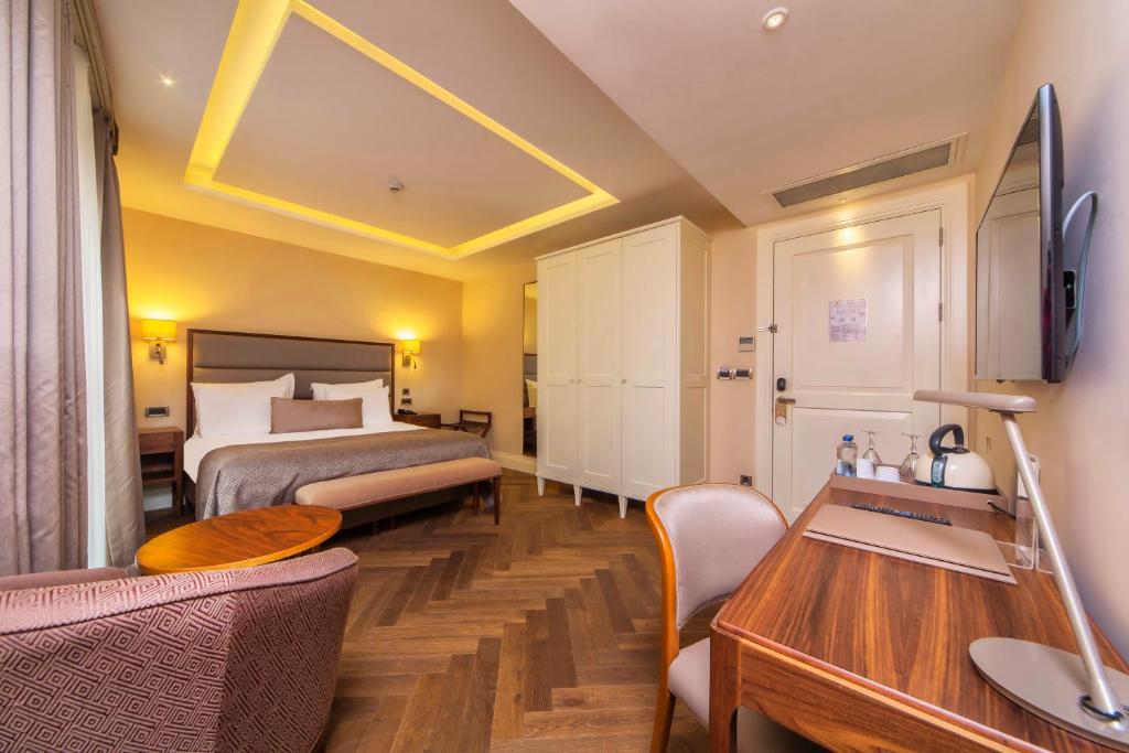 a hotel room with a bed and a desk at Hotel Morione & Spa Center in Istanbul