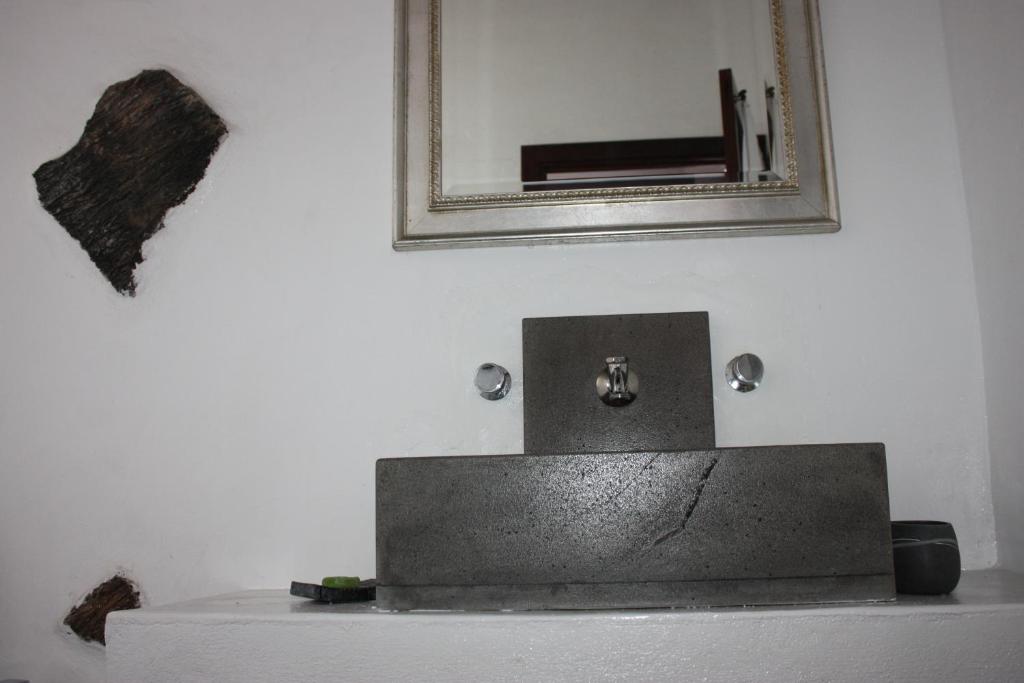 a bathroom sink with a mirror on a white wall at Casa Rural "La Molina" in Máguez