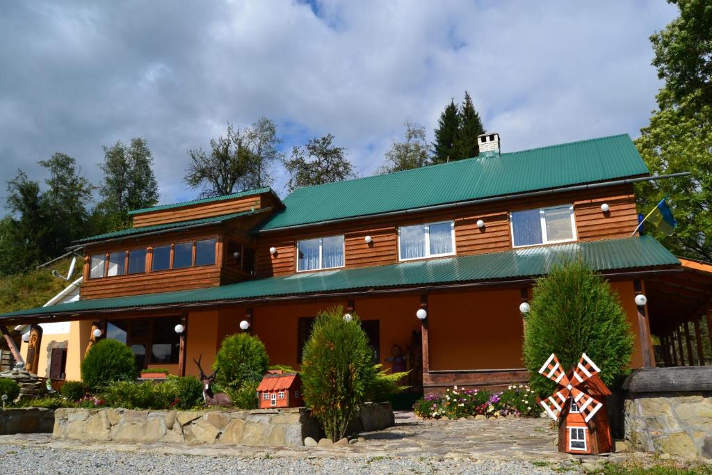 a large wooden house with a green roof at Fortuna in Lazeshchyna