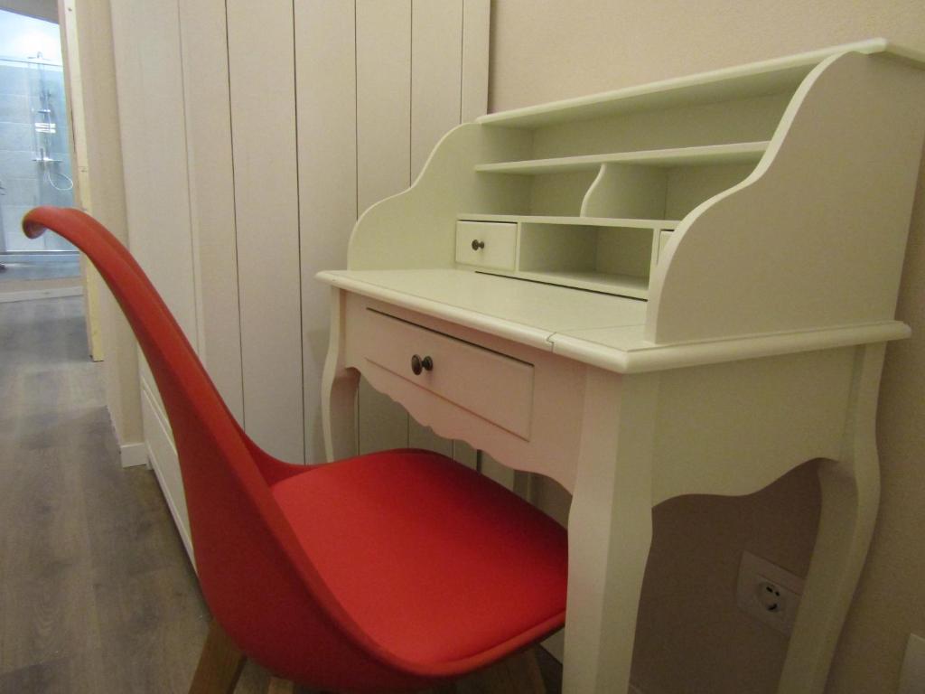a desk with a red chair in a room at Glam Resort Giulia in La Spezia