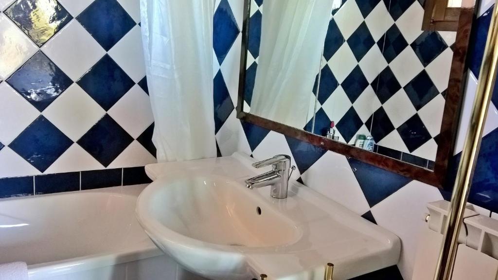 een badkamer met een wastafel, een spiegel en een bad bij Arcamyrtus in Alghero