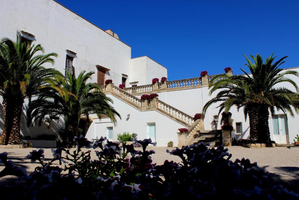 a building with palm trees in front of it at Masseria Carignani in Tuglie