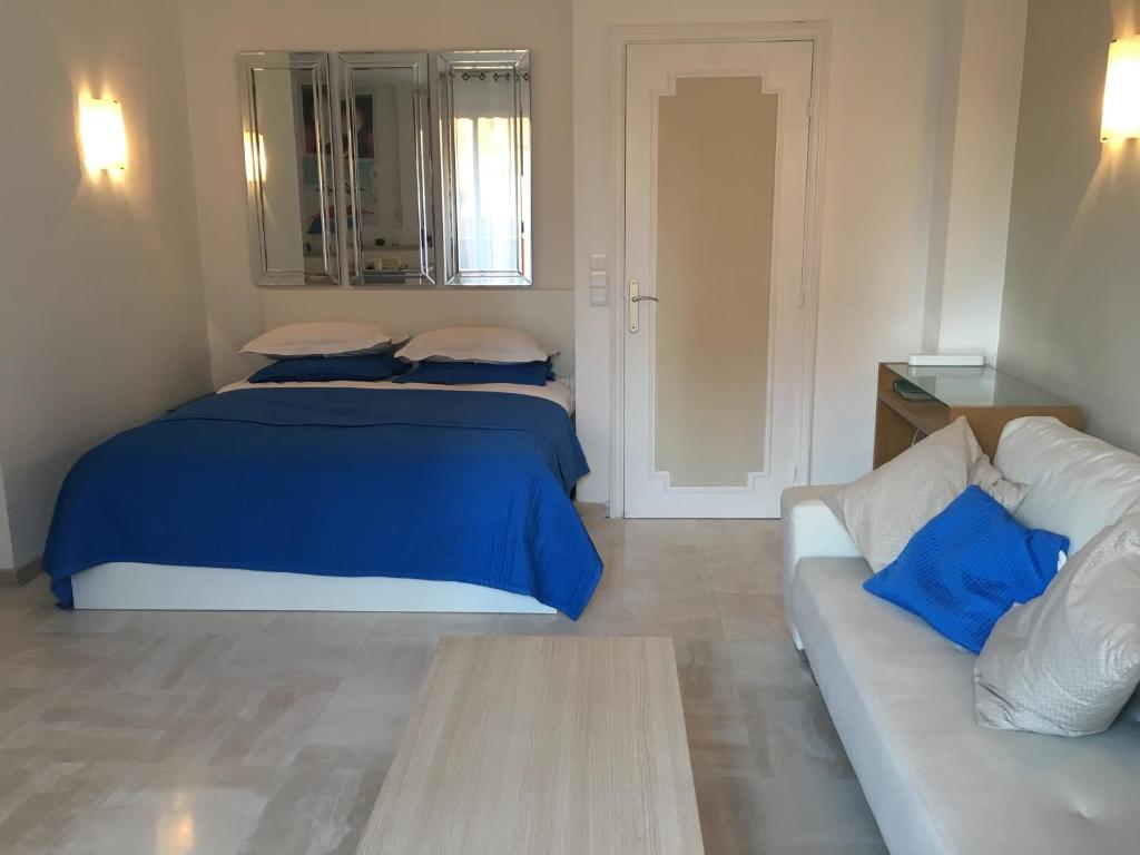 カンヌにあるParc De La Croisetteのベッドルーム(青いベッド1台、ソファ付)