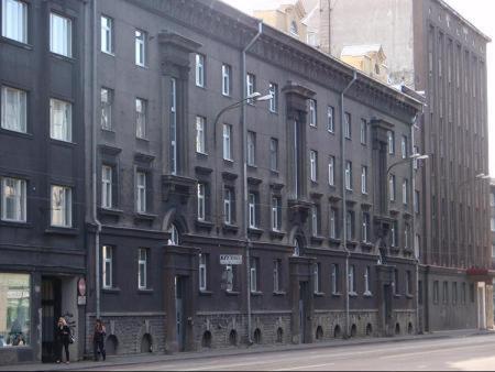 un gran edificio negro con gente parada frente a él en Economy Baltics Apartments - Narva 16, en Tallin