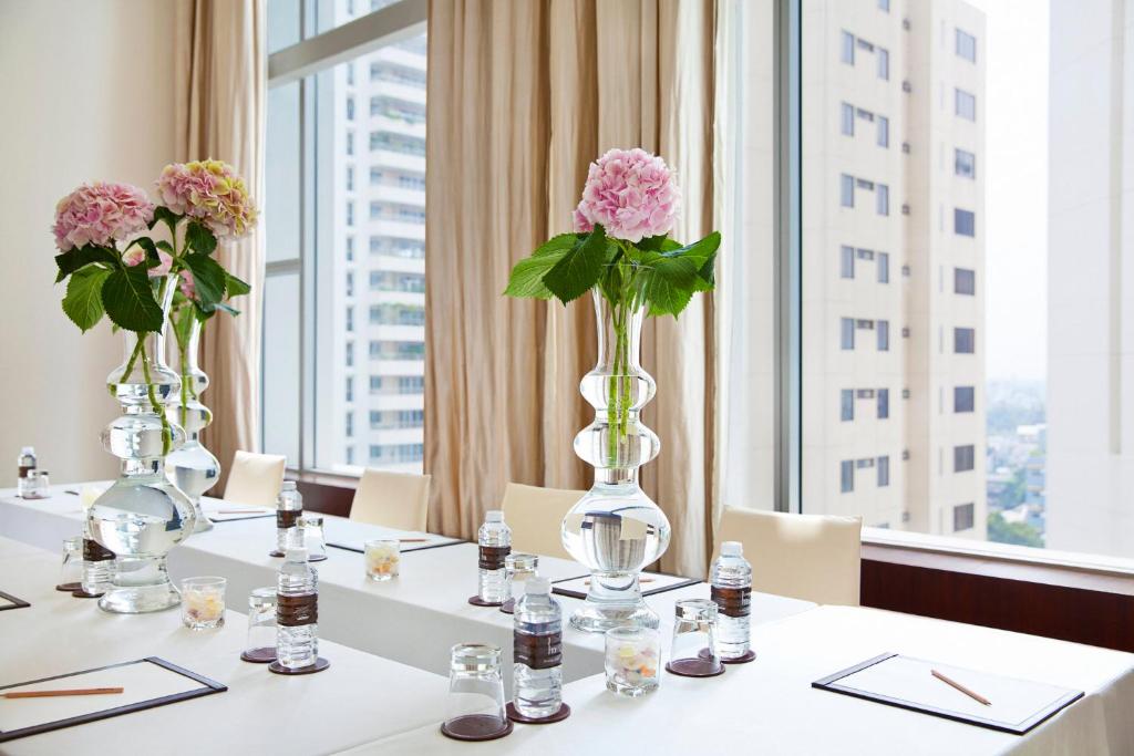 A bright meeting or dining table set beside city-facing windows.