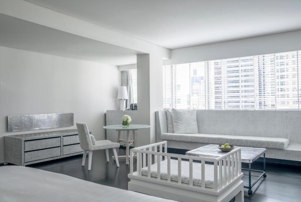 A spacious lounge with a long sofa, dining corner and high-rise city outlook.