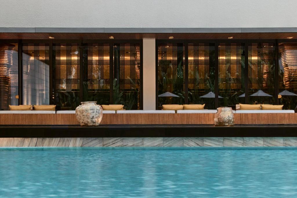 A bright blue pool extends toward a screened dining or lounge area.