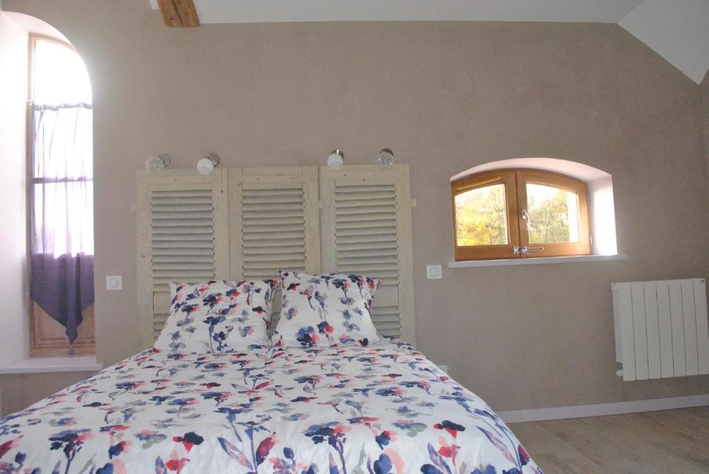 a bedroom with a bed and a window at Domaine de la Poyat in Légny