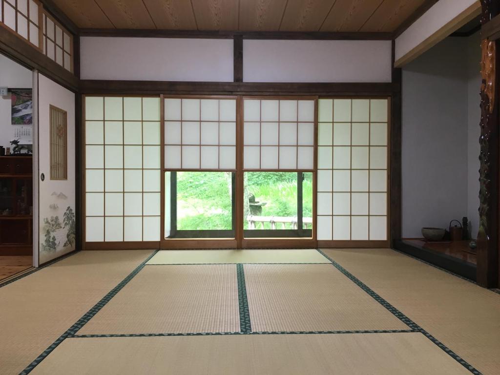 Pokój z dużym oknem i podłogą wyłożoną kafelkami w obiekcie Anzuan Nishida w mieście Ueda