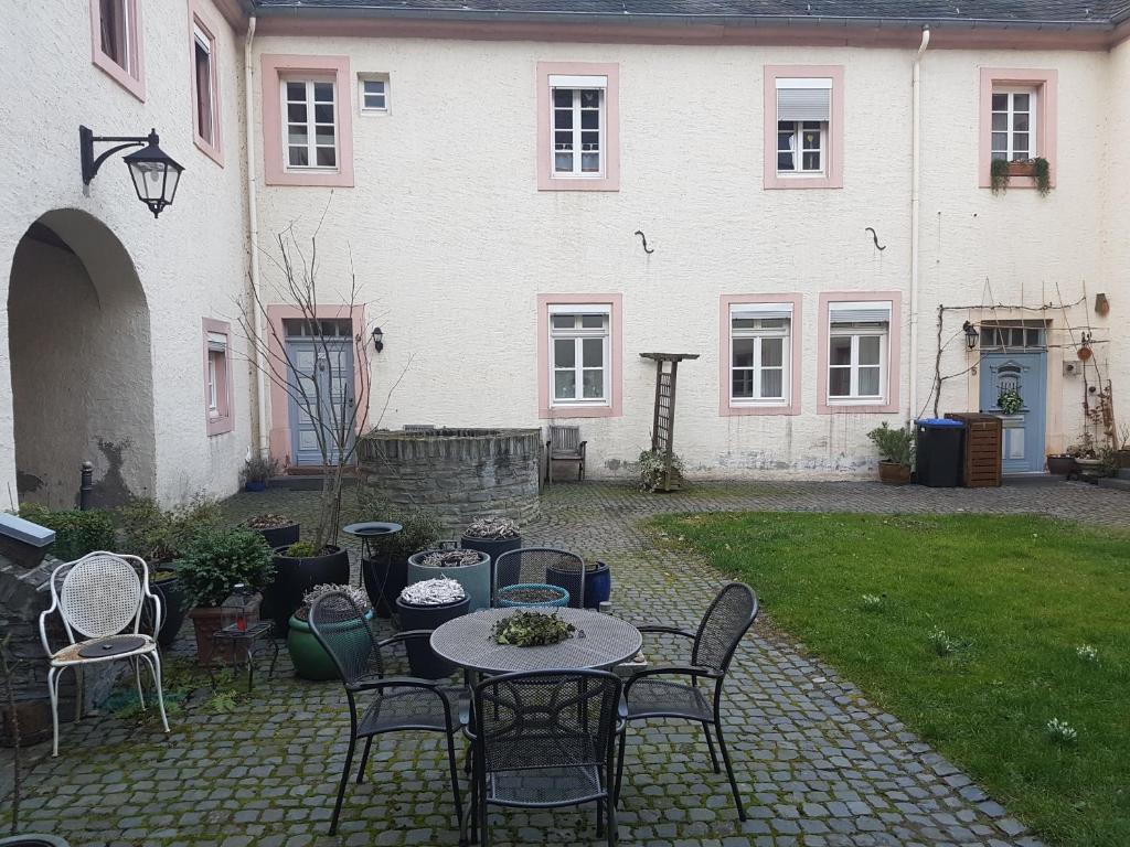 eine Terrasse mit einem Tisch und Stühlen vor einem Haus in der Unterkunft Weingut-Klosterhof in Brauneberg