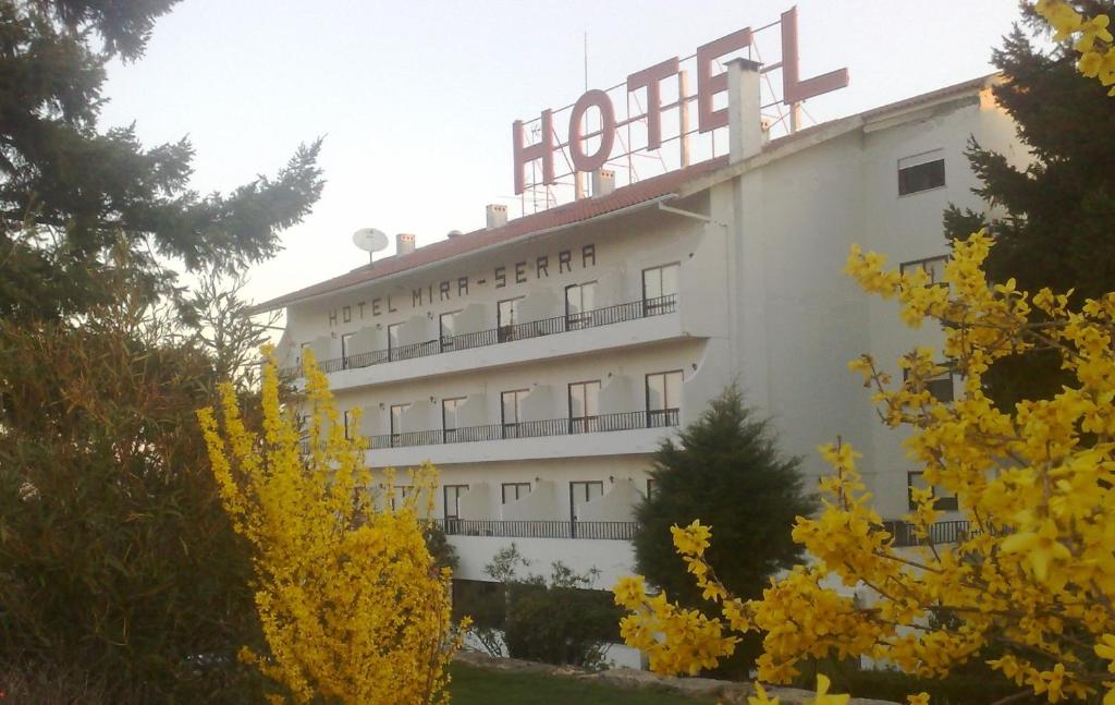 Un bâtiment blanc avec un panneau en haut dans l'établissement Hotel Mira Serra, à Celorico da Beira