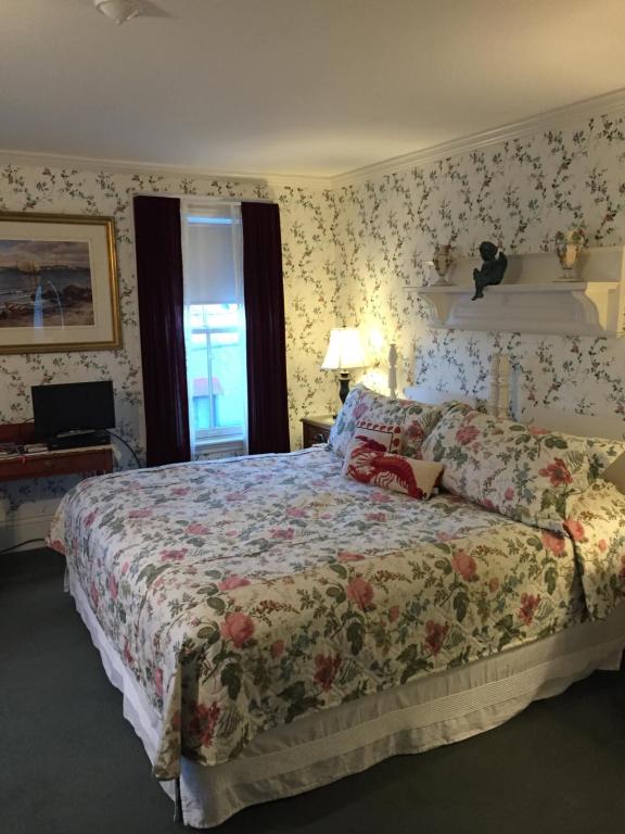 a bedroom with a bed with a floral bedspread at Lantana House in Rockport