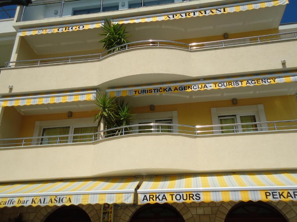 un edificio con un balcón con plantas. en Villa Grgo Apartments, en Tučepi