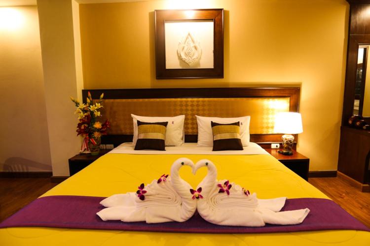 Madina Rayong Hotel في رايونغ: جعلوا اثنين من البجعات تبدو وكأنها قلوب جالسة على سرير
