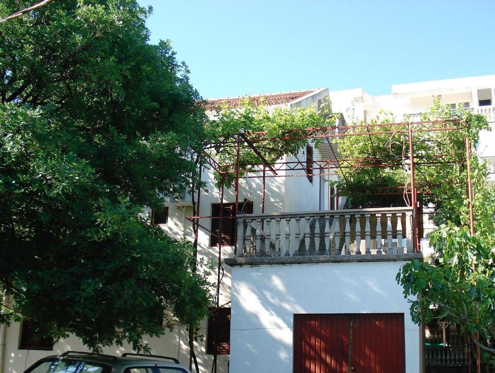 a balcony on the side of a building with trees at Apartments Aleksic in Sutomore