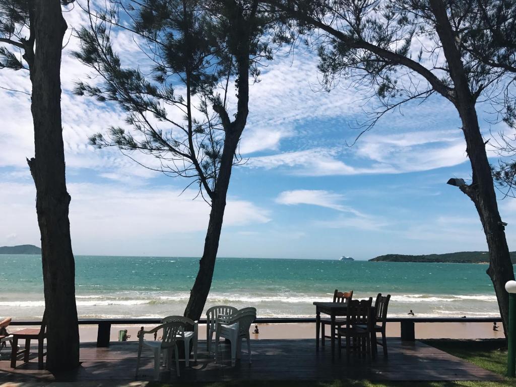 un tavolo e sedie su una spiaggia con l'oceano di Condominio Via Del Mare a Búzios