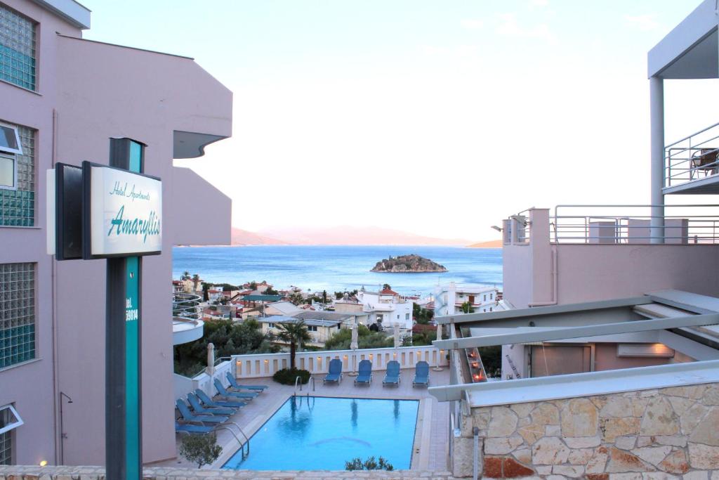 トロにあるAmaryllis Hotel Apartmentsのスイミングプールと海を望むホテルの景色を望めます。