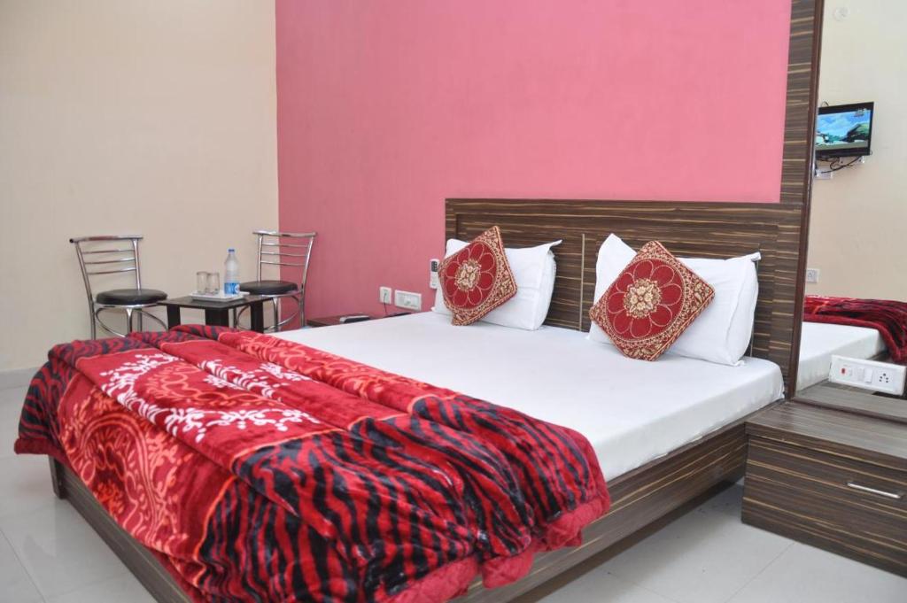 a bedroom with a large bed with a red blanket at Hotel M City in Amritsar