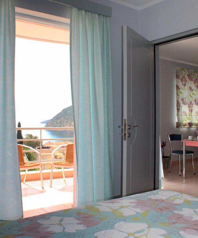 a bedroom with a bed and a view of a balcony at Amaryllis Hotel Apartments in Tolo