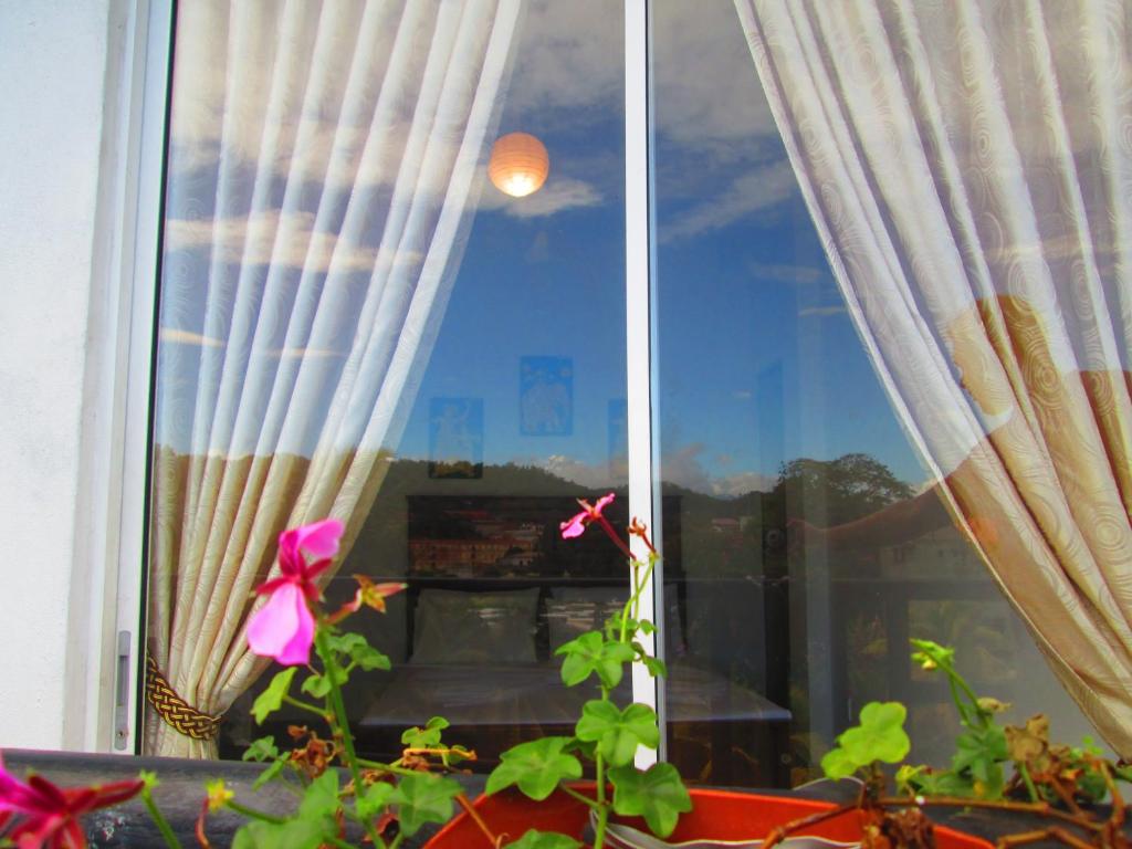 ein Fenster mit Blick auf den Himmel in der Unterkunft Kandyan Sweet Villa in Kandy