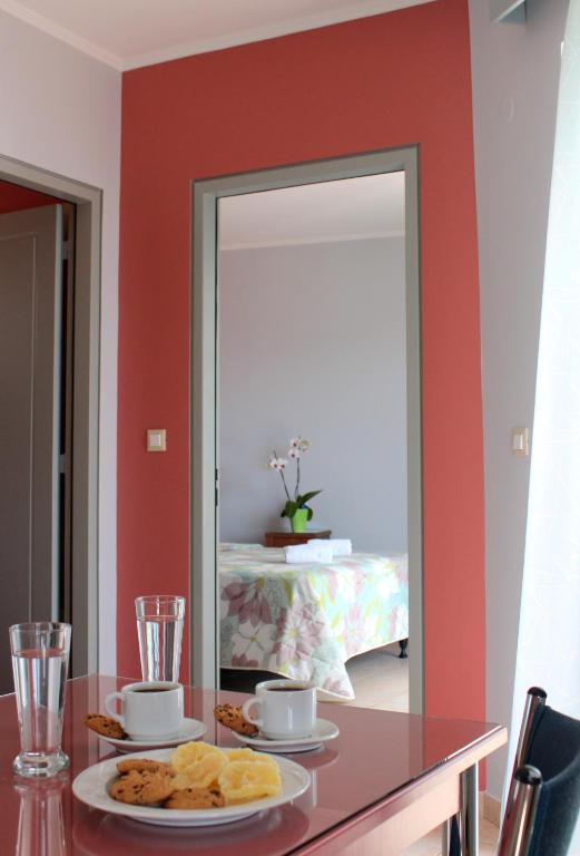 a table with a mirror and a plate of food at Amaryllis Hotel Apartments in Tolo