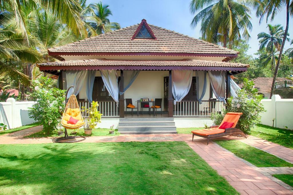 a home with a house with a yard with chairs at Beach Villa Morjim in Morjim