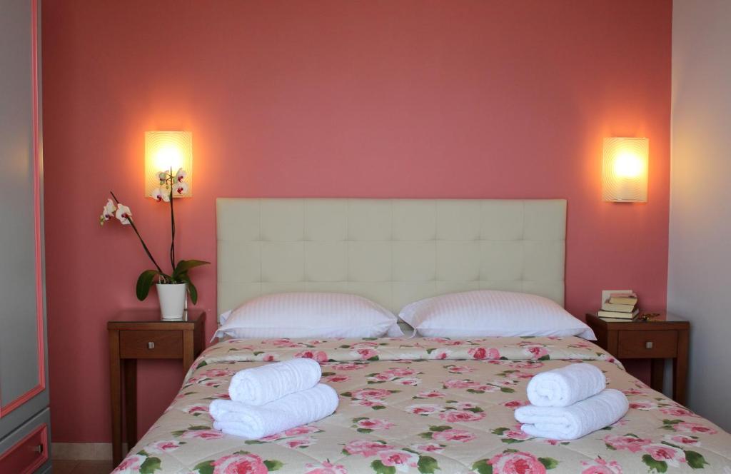 a bedroom with a bed with towels on it at Amaryllis Hotel Apartments in Tolo